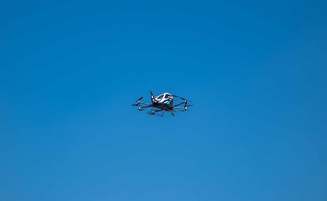 Modern drone flying in blue sky